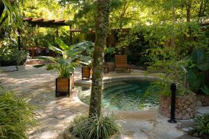 a pool in a garden with a table and chairs at Caracoral Hotel Boutique in Valle de Anton