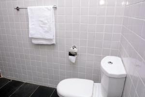 a bathroom with a white toilet and towels at Kampala suites Kisementi in Kampala