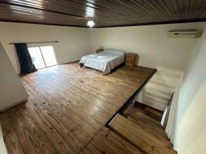 a room with a bed on a wooden floor at Central City in San Andrés de Giles