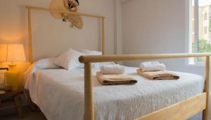 a bedroom with a bed with two towels on it at La Casita Bonita - 30m from the Arenal Beach - Private Parking in Jávea
