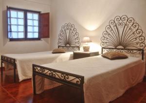 a bedroom with two beds and a window at Apartamento Os Compadres in Vila Nova de Milfontes