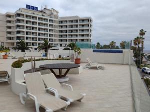 Un patio con mesa y sillas y un edificio. en Le Terrazze 7, en Puerto de la Cruz