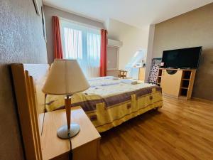 a bedroom with a bed with a lamp and a television at Gyöngy apartman in Zalakaros