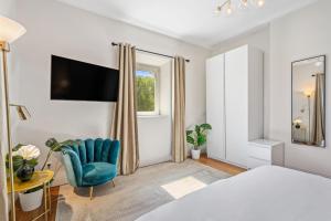 um quarto com uma cama, uma cadeira e uma janela em Elegant 3BR Home in Prime Limpertsberg Location em Luxemburgo