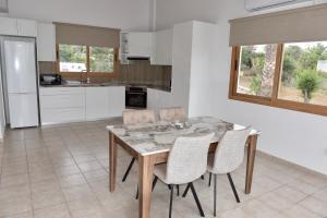 a kitchen with a wooden table and chairs at Kochili Villa in Pomos
