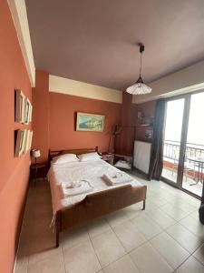 Un dormitorio con una cama y una ventana grande en Cozy Little Home, en Heraclión