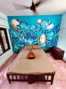 a room with a bed in front of a blue wall at Santa Maria Hostel Kovalam in Kovalam