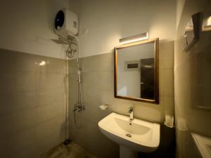 ein Badezimmer mit Waschbecken und Spiegel in der Unterkunft House of Merchants in Galle