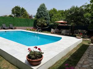 a swimming pool with flowers in a yard at Villa Onuk in Sapanca