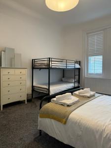 Un dormitorio con dos literas y una cómoda. en Spacious Victorian Birkdale Apartment with Garden, en Southport