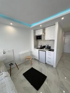 a kitchen with white cabinets and a table in a room at Tenerife Sea View Sun Beach Apartment 222 in Playa Fañabe