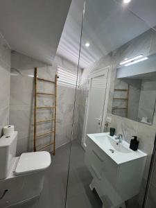 a white bathroom with a toilet and a sink at Tenerife Sea View Sun Beach Apartment 222 in Playa Fañabe