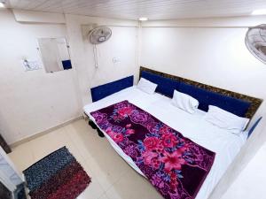 a small bedroom with a bed with a purple blanket at BLUE TOWER in Ujjain