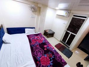 a bedroom with a bed with a purple blanket on it at BLUE TOWER in Ujjain