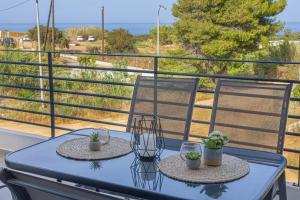 a table and two chairs on a balcony at Ammira Mare Apartment in Agia Pelagia