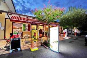 a pizza shop with a sign in front of it at Camping Bella Italia in Peschiera del Garda