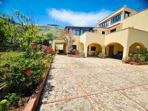 a house with a stone walkway in front of it at L'Angolo del Saraceno in Carini