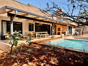 a house with a swimming pool in the backyard at Pumba Lodge Hoedspruit in Hoedspruit