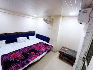 Un dormitorio con una cama con una manta morada. en Blue tower suites, en Ujjain