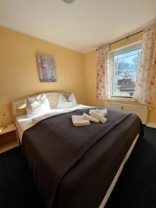a bedroom with a large bed with two towels on it at Hotel-Pension Zur Mole in Wiek auf Rügen 