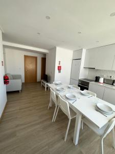 a white table with white chairs in a kitchen at Carcavelos Beach Shared Serviced Apartment 12 in Oeiras +5 photos