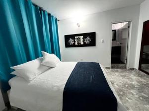 a bedroom with a large bed with blue curtains at Apartamento Edificio calima in San Andrés