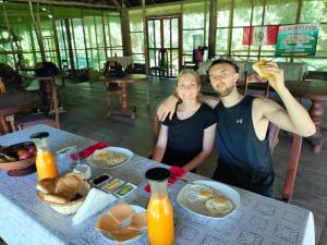 a man and a woman sitting at a table with food at Amazon Jaguar Adventure & Lodge in Iquitos