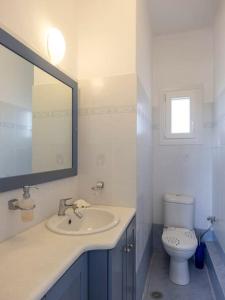 een witte badkamer met een wastafel en een toilet bij Angel Serenity Villa in Kampos Paros +12 foto's