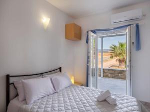 a bedroom with a bed and a sliding glass door at Angel Serenity Villa in Kampos Paros