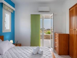 een slaapkamer met een bed en een glazen schuifdeur bij Angel Serenity Villa in Kampos Paros