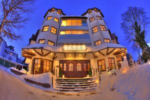 a building covered in snow at night at Boutiquehotel Liebesglück - adults only in Winterberg
