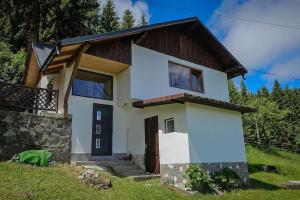 a white house with a wooden at Chalet Dor de Munte in Predeal