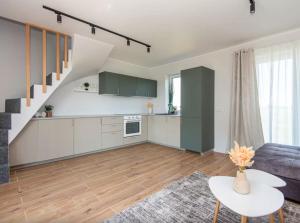 an open kitchen and living room with a staircase at Kopų banga in Palanga