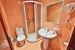 a bathroom with a toilet and a sink and a shower at Pension Santos in Vimianzo +45 photos