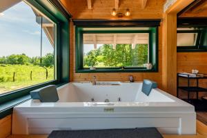 a large bath tub in a room with a window at River House Moon in Gospić +59 photos