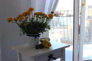 a vase of flowers on a table next to a window at Casa Blu Cobalto in Maiori