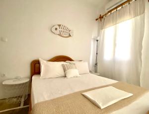 a bedroom with a bed with a fish clock on the wall at Villa Ambelas - Traditional House in Ambelas