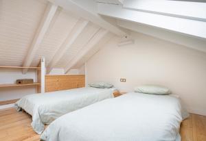 two beds in a room with a attic at La Casina de Glorina in Muros de Nalón