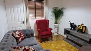 a living room with a couch and a red chair at Amani Bungalow in Brandon