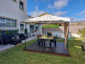 a table under an umbrella in a yard at Vivenda Cordeiro in Bárrio