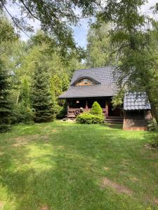ein Haus mit einem grünen Hof davor in der Unterkunft Domek Nowy Lubiel in Lubiel Stary