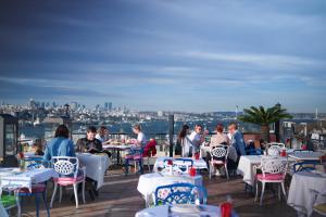 a group of people sitting at tables on a patio at Raymond Blue Hotel in Istanbul
