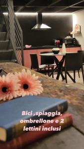 a book sitting on a table with flowers on it at Loft Deluxe centralissimo-Antica Vetreria in San Benedetto del Tronto