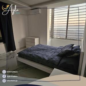 a bedroom with a bed and a window at Ayla Chalets in Amman
