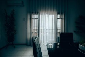 a living room with a glass table and a window at Flor do Mar in Nazaré
