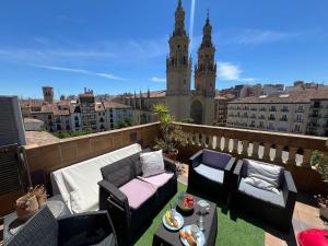 a balcony with furniture and a view of a city at ATICO Catedral Barbacoa y Aire sin ascensor By Apartamentos Logrono in Logroño