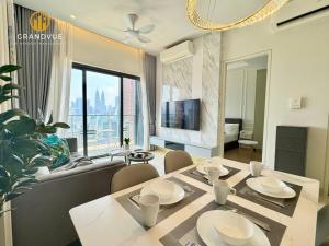 a dining room and living room with a table and chairs at Lucentia BukitBintang KlccView InfinityPool By HeyStay Management in Kuala Lumpur