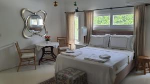 a bedroom with a large bed with a mirror and a table at Yasos By The Sea in Çeşme