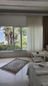 a bedroom with a window and a bed and a table at Yasos Suites in Çeşme