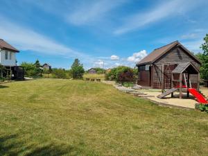 a yard with a playground and a house at Privati valda in Šventoji